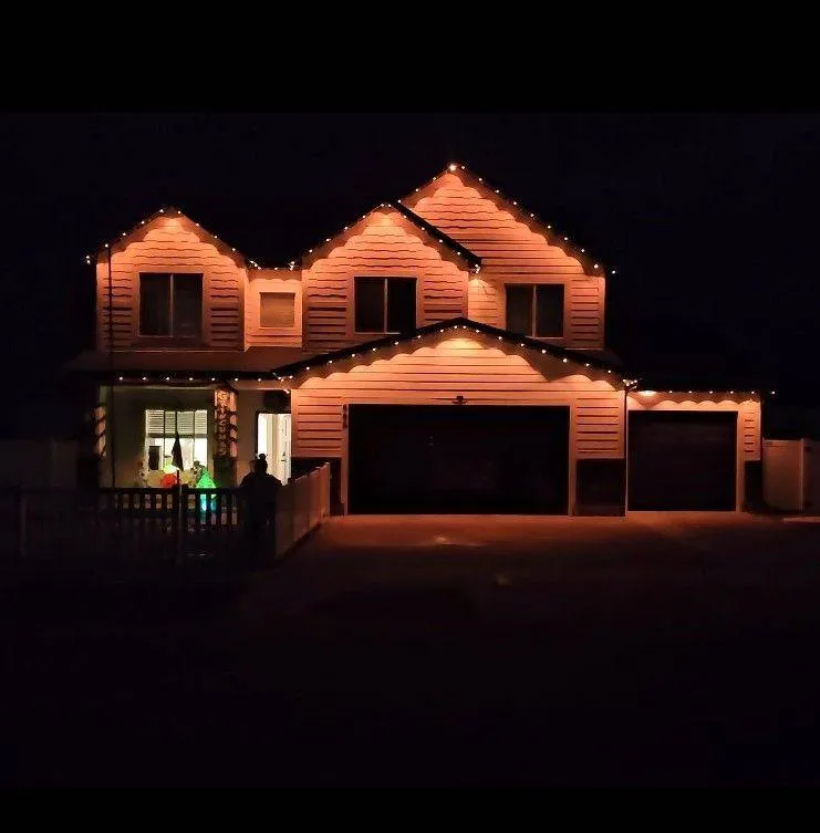 Warm-white permanent lighting on a two-story Cache Valley home