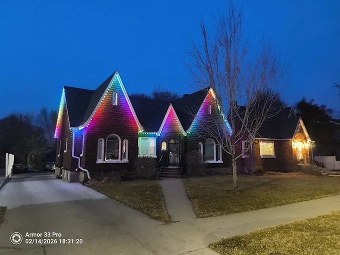 Cottage-style home with multi-color permanent roofline scene at dusk